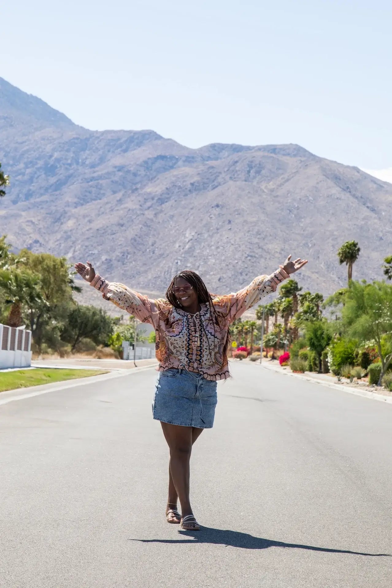 Person standing on a road with mountains in the background